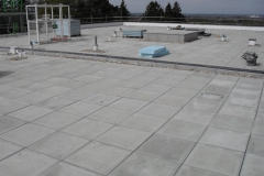 Flat roof construction using paving pads