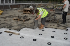 Paving a podium deck using plastic spacers
