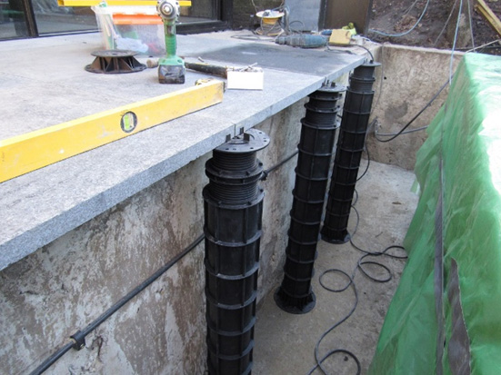 An image of adjustable support pedestals being installed at Grove Park, Chiswick