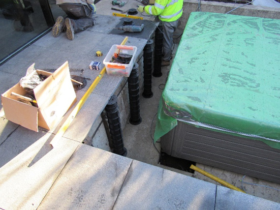 An image of adjustable support pedestals being installed at Grove Park, Chiswick