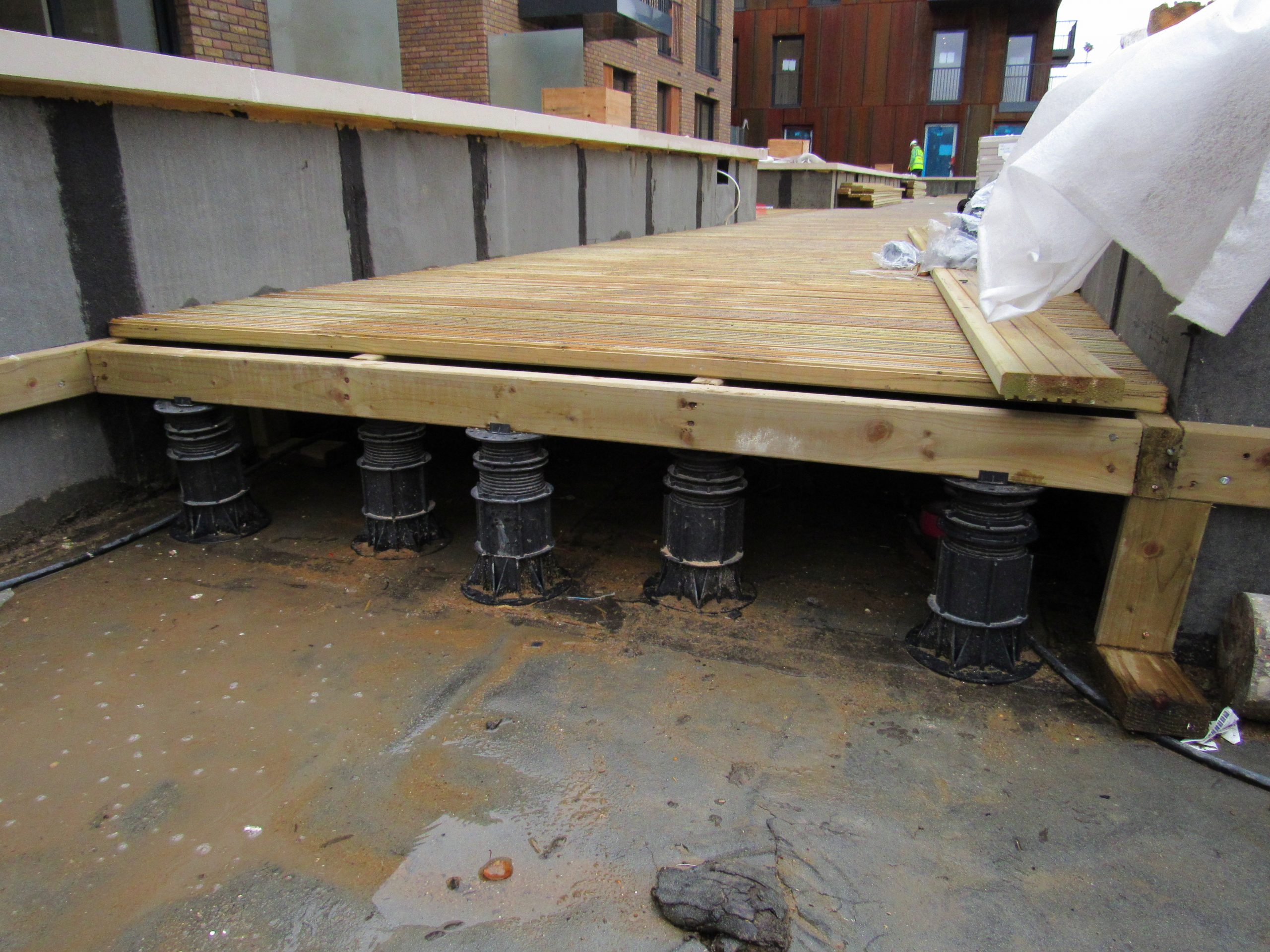 Adjustable decking pedestals joists and deck boards